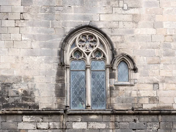 Традиционное старинное готическое окно на каменной стене — стоковое фото