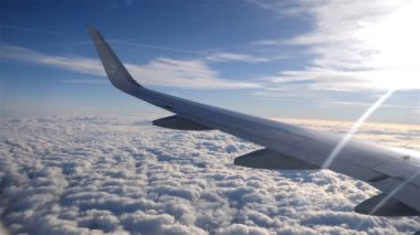 Kanat uçak veya güzel mavi gökyüzü arka plan bir jet ve taşıma kabarık bulutlar. Güneşli bir hava görünümünü yüksek. Gerçek zamanlı görüntüleri
