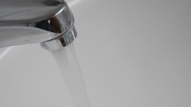 Acqua che scorre dal rubinetto al lavandino. Primo piano. — Video Stock