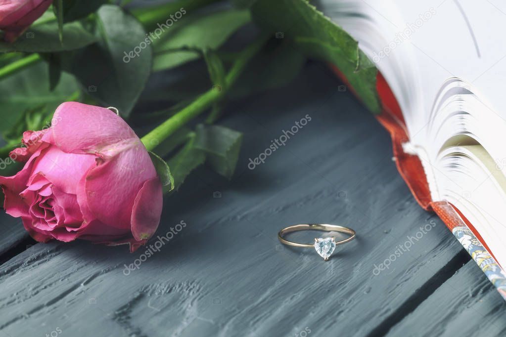 delicate roses on a book with a ring