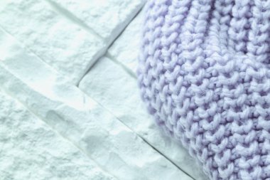 Örme ceket beyaz tuğla zemin üzerine mavi