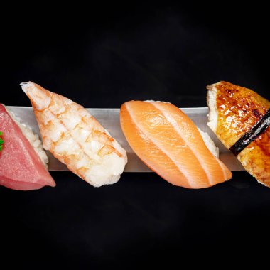 Japon dürümleri ve deniz ürünleri suşisi. Siyah arka planda katana kılıcı.