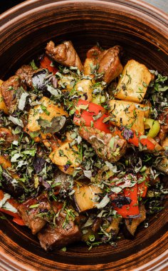 Kurutulmuş sebze güveci. Yuvarlak, siyah bir tabakta.