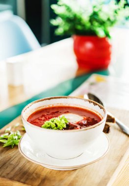 Çorba çorbası. Ekşi kremalı. Tahtada beyaz bir tabakta.