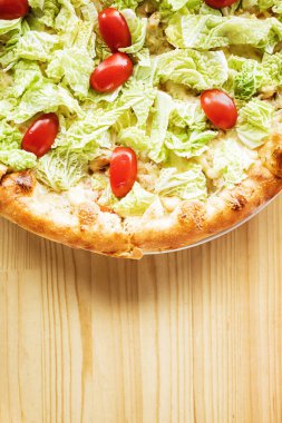 Pizza ahşap masanın üstünde.