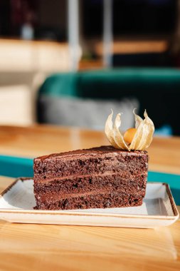 Kare tabakta bir parça çikolatalı pasta, köpüklü.