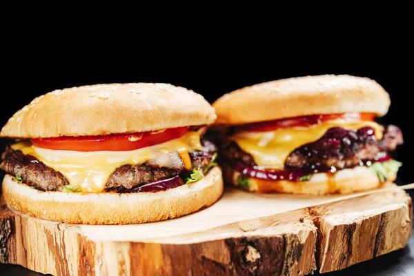 Два Гамбургери Дерев Яній Дошці Пергаментом Чорному Тлі — стокове фото