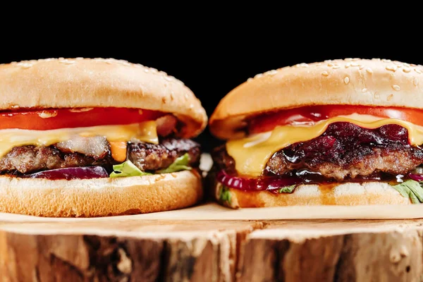 Два Гамбургери Дерев Яній Дошці Пергаментом Чорному Тлі — стокове фото