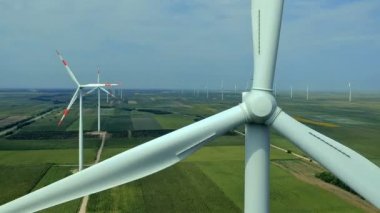 Havadan görünümü A elektrik yeşil alana rüzgar türbini üretme. Dönen bir rüzgar türbini yakın çekim. 