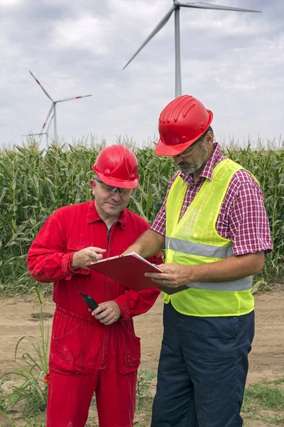 Twee Medewerkers Dragen Hard Hat Bespreken Klembord Document Tegen Turbines — Stockfoto