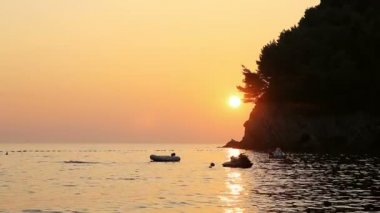 Görkemli turuncu günbatımı okyanus. Demirli Jet Ski ve gün batımında tekne. Denizde yansıtan güneş. Adam yüzme günbatımında.