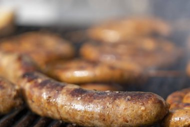 Barbekü Izgara sıcak kömürlerin üzerinde pişirme sosis. İştah açıcı Barbekü sosis bir Barbekü yanıyor görünümü kapatın. Seçici odak. 