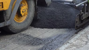 Asfalt kaplama makine içinde hareket. Asfalt yol inşaat alanında makine döşeme. Yol yapımı üzerinde takım çalışması. Taze asfalt yol yapımı sırasında döşeme makinaları.