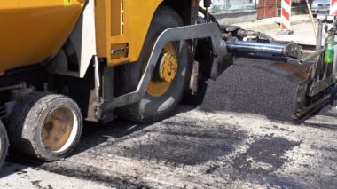 Yol inşaat çalışmaları - yeni asfalt yol. Taze asfalt yol yapımı sırasında Döşeme makinesi.