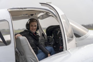 Özel Uçağın Kokpitinde Kulaklıklı Gülümseyen Genç Kadın Pilot