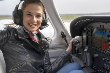 Uçak Kokpitinde Kulaklıklı Gülümseyen Genç Kadın Pilot