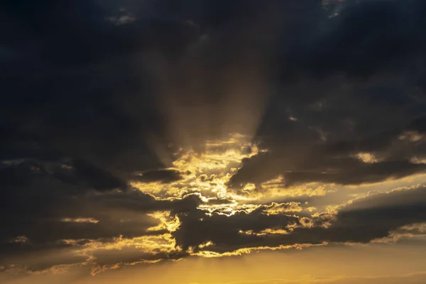 Rayos dorados del sol rompen a través de las nubes - Hermoso fondo natural — Foto de Stock