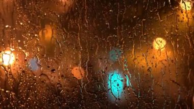 Yağmurlu Pencereden Gece Şehri. Yağmur Yağışı Fırtına sırasında Night City Street Karşı Cam Pencere üzerinde. Yağmurlu Pencereden Şehir. Yağmurlu Bir Gecede Şehir Işıkları ve Trafik.