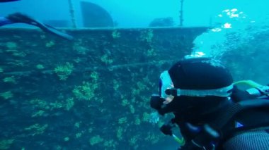 Dalgıç Büyük Bir Shipwreck keşfetmek - Yavaş Hareket. Scuba Diver Ok İşareti Sualtı gösteren. Dalgıç batık bir gemi araştırıyor.