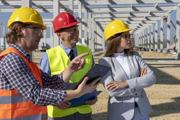 Porträt eines Vorarbeiters mit Tablet, eines reifen Geschäftsmannes und einer jungen Architektin auf der Baustelle — Stockfoto