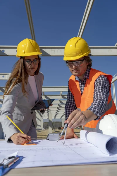 Giovane architetto e ingegnere donna che controlla il progetto di costruzione in cantiere — Foto Stock