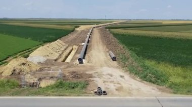 Petrol ve Gaz Boru Hattı İnşaat Alanı 'nın Üzerinde Uçmak - Türk Akımı. Borular siperin yanındaki destekleyici kum torbalarının üzerine yerleştiriliyor, birbirine kaynakla tutturuluyor ve paslanmayı önlemek için kaynak eklemleri tutkal ile kaplanıyor. Boru hattı inşaat halinde.