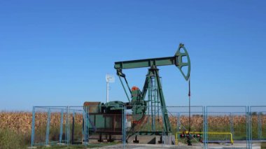 Jack 'in petrol kuyusundan ham petrol çıkarmasını sağla. Fosil Yakıt Enerjisi. Petrol endüstrisi ekipmanları. Petrol Endüstrisi Mavi Gökyüzüne Karşı Jack 'i Pompaladı.