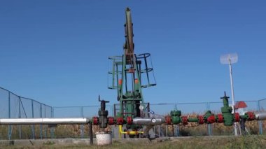Petrol kuyusundan ham petrol çıkarıyorum. Fosil Yakıt Enerjisi. Petrol endüstrisi ekipmanları. Petrol Sahası Mavi Gökyüzüne Karşı Pompa.