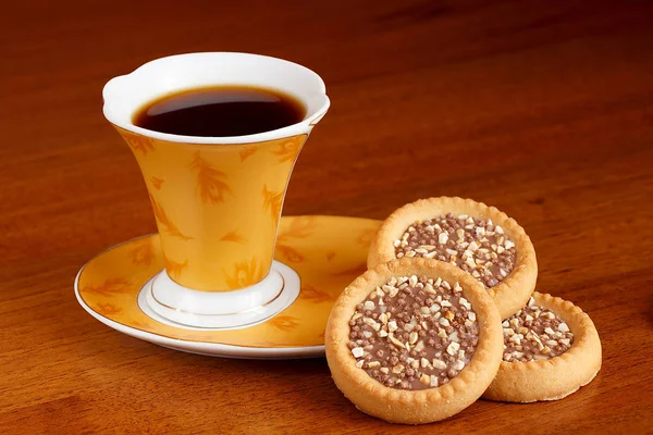 Une tasse de café se tient sur la table avec de délicieux bonbons — Photo