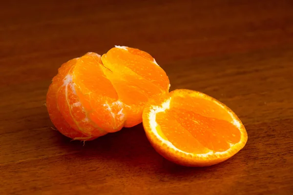 Schneiden leckere saftige reife Mandarine aus nächster Nähe auf einem dunklen Hintergrund — Stockfoto