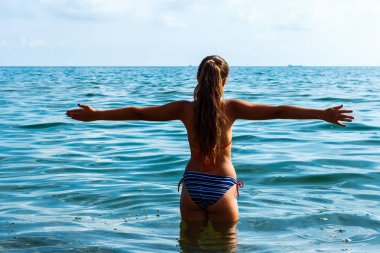 Parlak güneşli bir günde kız suya atlamak için gidiyor