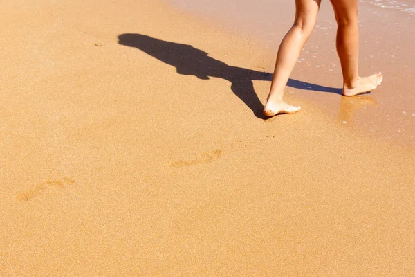 Pés menina descalça perto da borda das águas pelo mar Fotografia De Stock