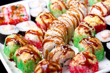 Beyaz bir tabakta değişik suşi çeşitleri.