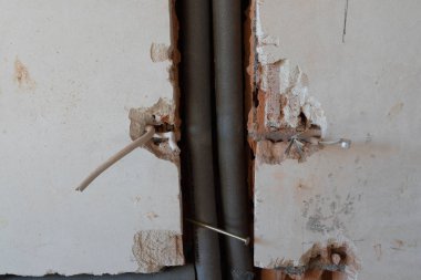 zarar gören bir kablo ile duvardaki izole Kalorifer boruları