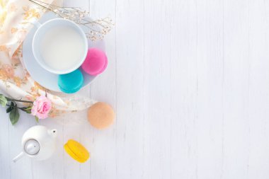 macarons veya bademli kurabiye ve süt tatlı tatlı güzel ahşap antika arka plan dokusu üzerinde yemek.