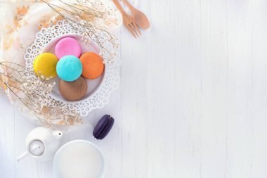 macarons veya bademli kurabiye ve süt tatlı tatlı güzel ahşap antika arka plan dokusu üzerinde yemek.