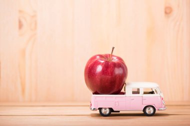 ahşap zemin arka plan ile oyuncak araba elma kırmızı