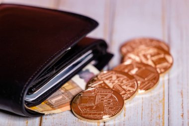 Bitcoin cüzdan üzerinde hafif bir arka plan resmini sanal ekonomi unsurları sembolize ediyor..