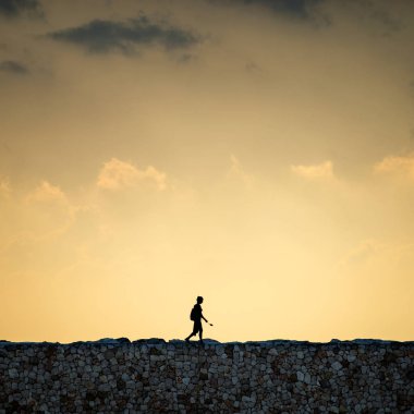 Bir kadın bir noktadan diğerine tek başına gider. Trajik gökyüzü ve gün batımı