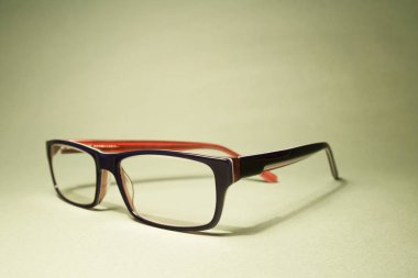 Okuma gözlüğü yeşil bir arka plan üzerinde.