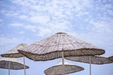 Plaj sezon başında bir kavramı denizde tatil ve denize geziler gibi şemsiye gökyüzüne karşı plaj.