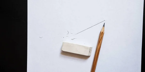 Eraser and pencil as tools for designing. The line is drawn on a white sheet of paper and some of it is erased.