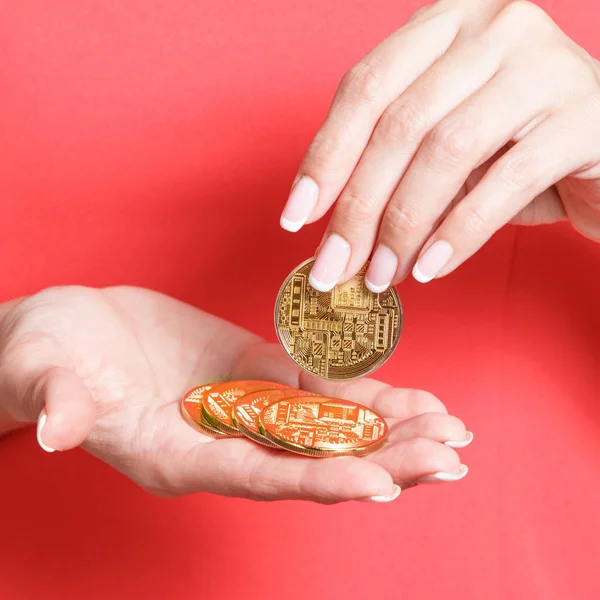 ICO ve Token Satılık kavramı - ilk madeni para sunan eller. Kırmızı bir bluz kadında kripto altın elinde tutan.