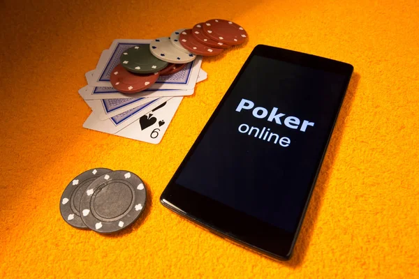 Poker online with accessories for casinos. In the picture there is a smartphone as a symbol playing to online game.