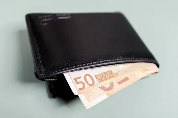 Black wallet with euros is a concept of average household income. A picture can be used to illustrate a blog about money or about a household spending.