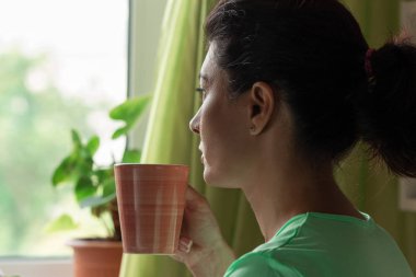 Orta yaşlı bir kadın ve bir sabah sakin ve mutlu bir ruh hali içinde kahve