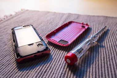 Kavram - onarmak için sağdaki. Bir dava ve tüketici elektroniği ve aletleri sabitleme bir sembolü olarak bir tornavida ile cep telefonu.