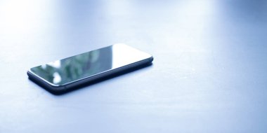 Sabah güneşi bir tabloda üstünde hareket eden telefon. Metninizi buraya için oda.