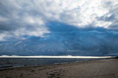 Bulutlar ve boş kumsala Baltık Denizi'nin üzerinde Rüzgar.
