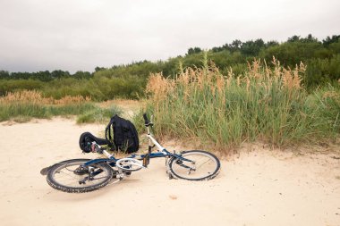 Ekoloji korumak için bir yol olarak bisikletle seyahat kavramı. Bir bisiklet ve bir sırt çantası plajın kumları üzerinde.